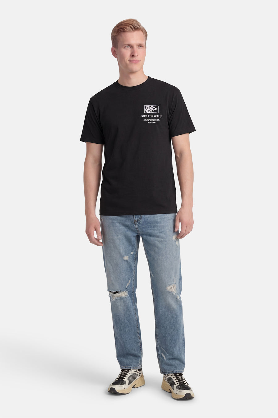 Zwart T-shirt van VANS “OFF THE WALL”, gedragen met gescheurde jeans en sneakers.
