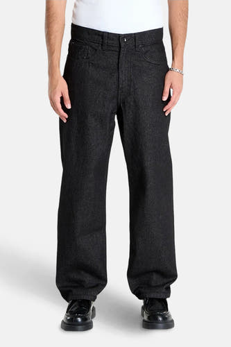 Jean en denim noir droit de VANS "OFF THE WALL", complet avec un bracelet argenté et des chaussures noires.