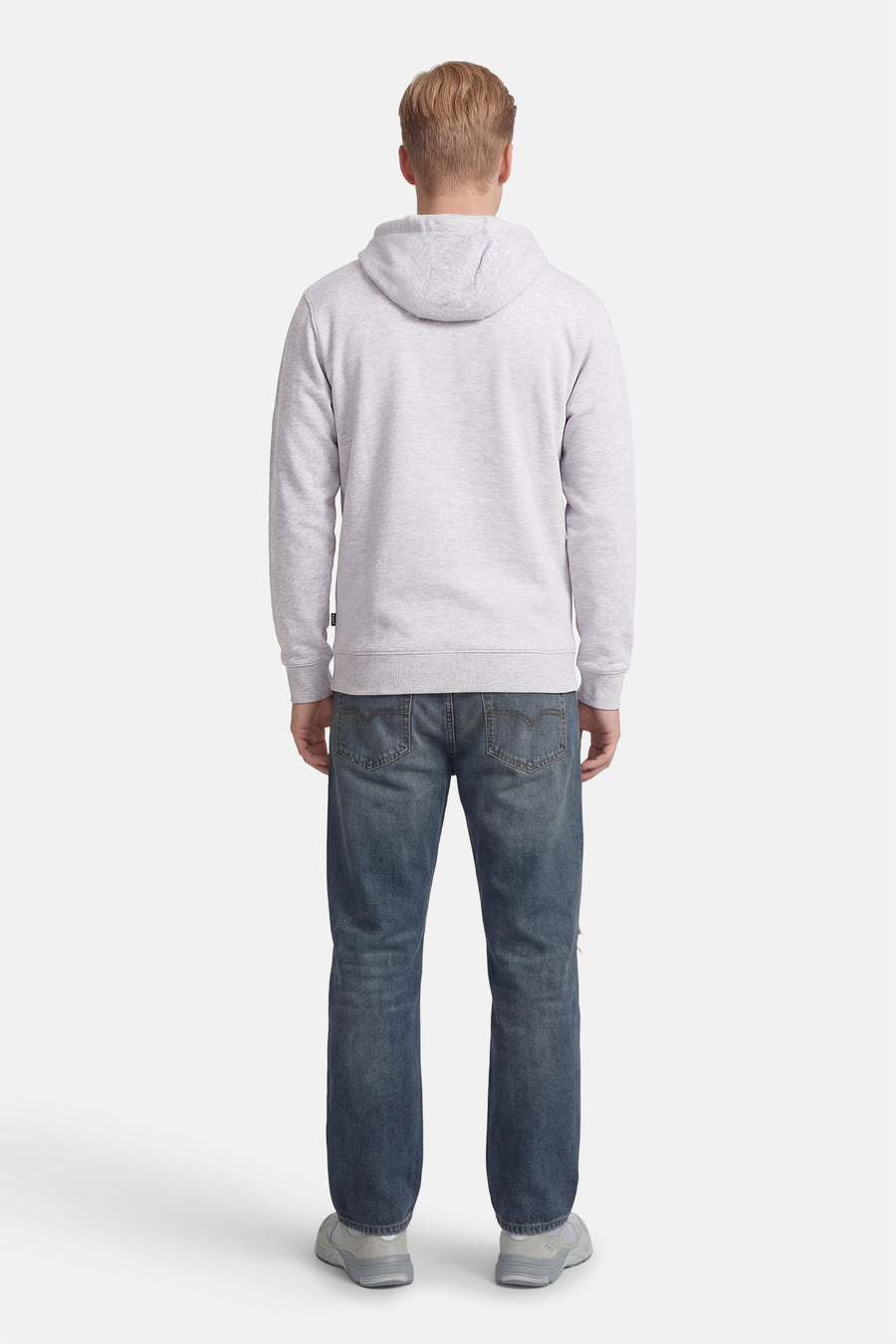 Grijze sweater met kap van VANS “OFF THE WALL”, gezien van achteren, gecombineerd met blauwe jeans en grijze sneakers.