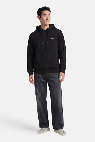 Zwarte sweater met kap van VANS, met trekkoorden en een buidelzak aan de voorkant, gecombineerd met grijze jeans en lage sneakers.