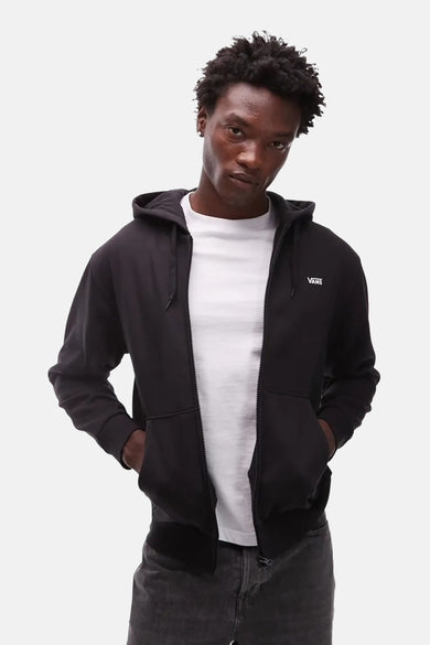 Gilet noir VANS "OFF THE WALL", avec fermeture éclair et capuche, porté sur un t-shirt blanc.