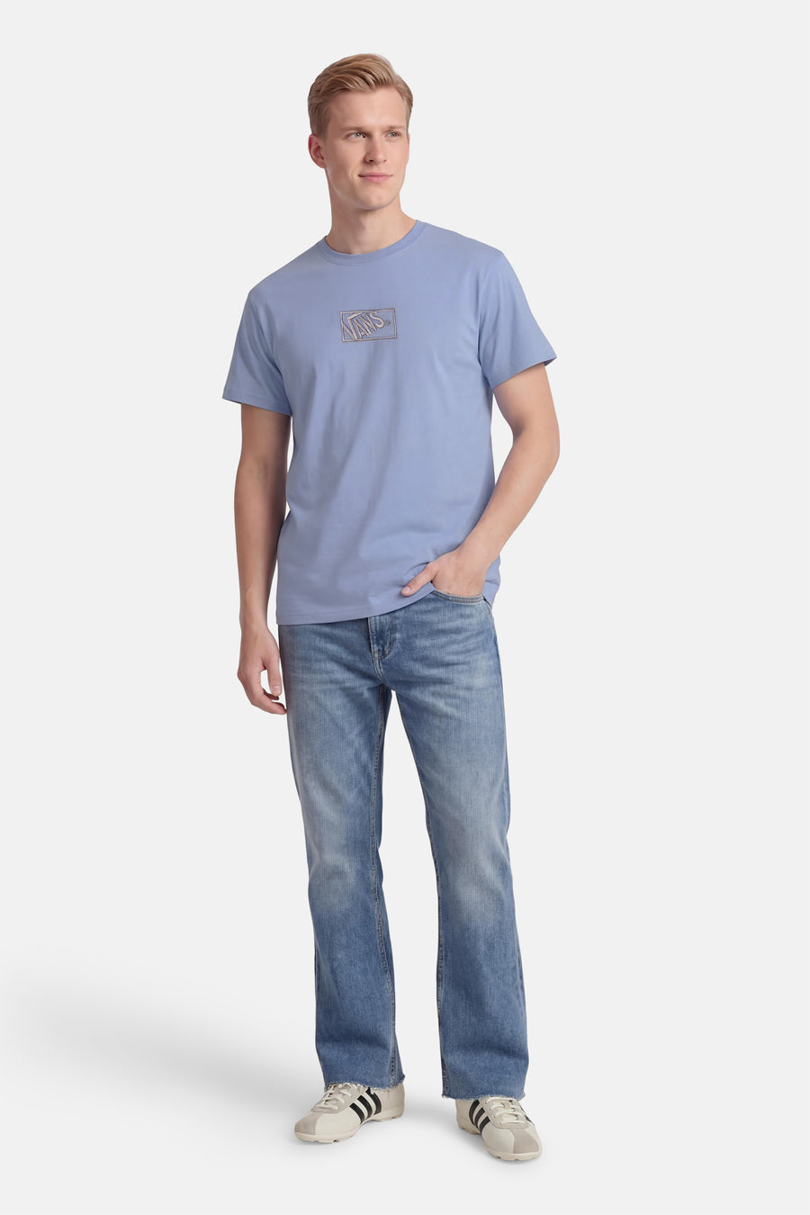 Blauw T-shirt van VANS “OFF THE WALL”, met korte mouwen en logo op de borst, gedragen met jeans.
