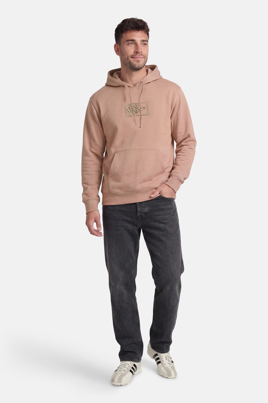 Beige sweater met kap van VANS “OFF THE WALL”, met lange mouwen en een kangaroozak, gecombineerd met zwarte jeans en sneakers.
