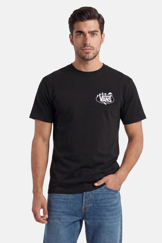 Zwart T-shirt van VANS met wit ovaal VANS-logo met skelet, handen en 'Since 1966', gedragen door een man in jeans.