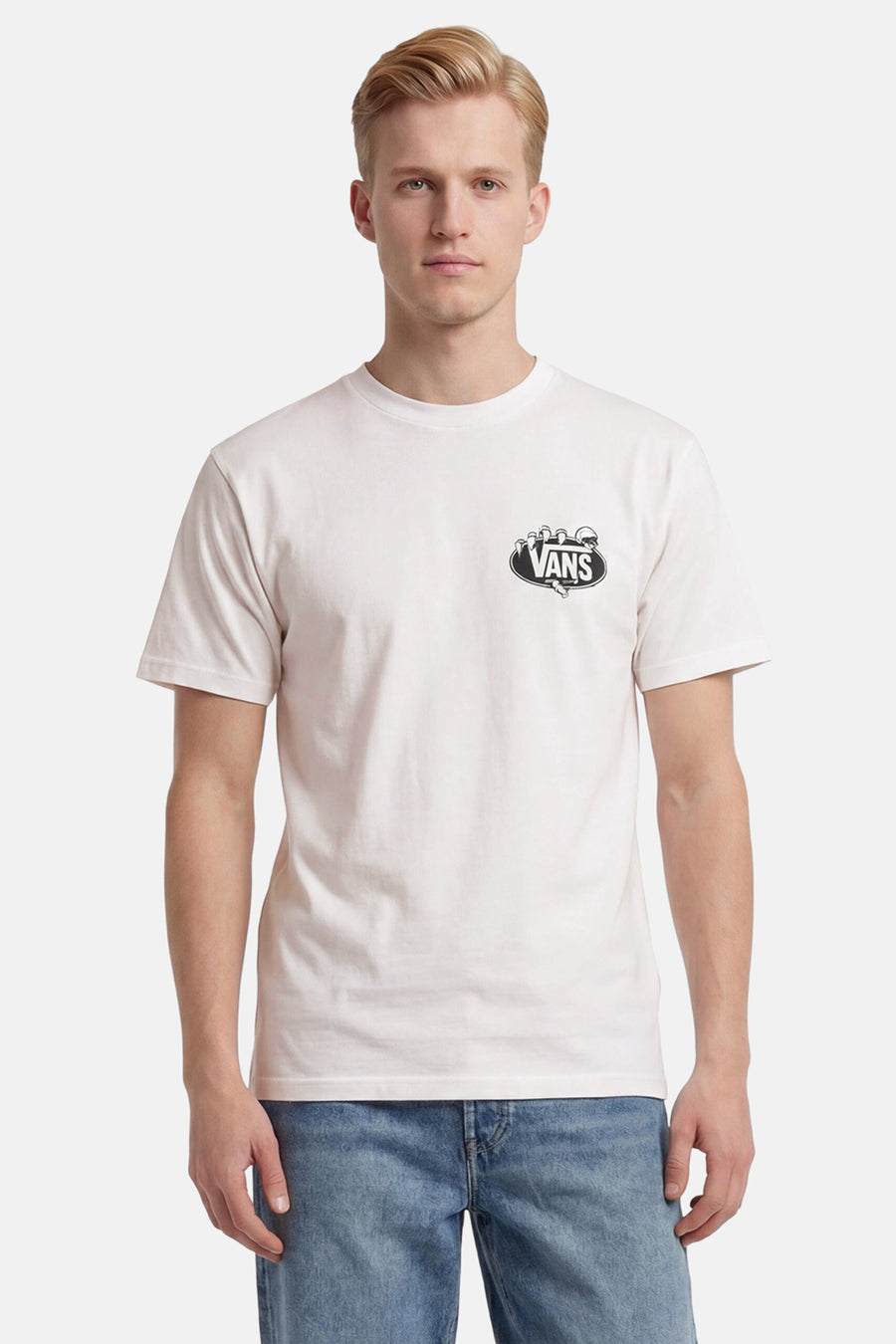 Wit T-shirt van Vans met zwart ovaal logo van skeletachtige handen op de borst, gedragen door een man in jeans.
