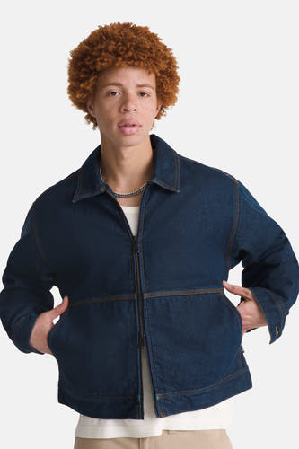 Donkerblauw denim jeansjas van VANS “OFF THE WALL”, met zilverkleurige ketting en man met rood krullend haar.
