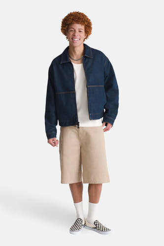 Donkerblauwe denim jeansjas van VANS “OFF THE WALL”, met beige shorts, witte sokken en dambord sneakers.