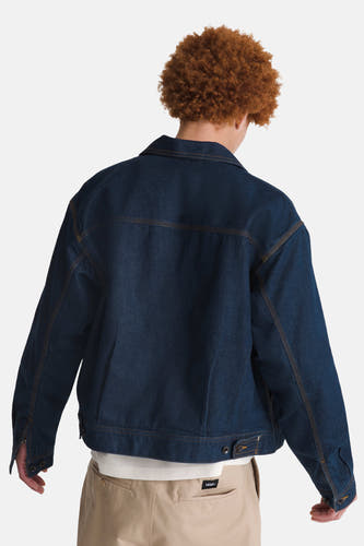 Donkerblauwe jeansjas van VANS “OFF THE WALL” met lange mouwen en beige broek.
