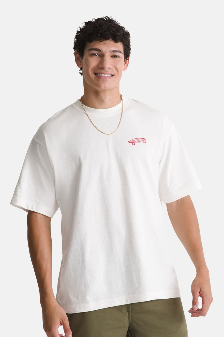 T-shirt blanc à manches courtes VANS "OFF THE WALL", avec un petit logo rose sur la poitrine, porté avec une chaîne dorée.