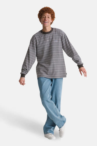Multikleurig T-shirt met lange mouwen van VANS “OFF THE WALL”, met een gestreept patroon en gedragen met jeans en sneakers.