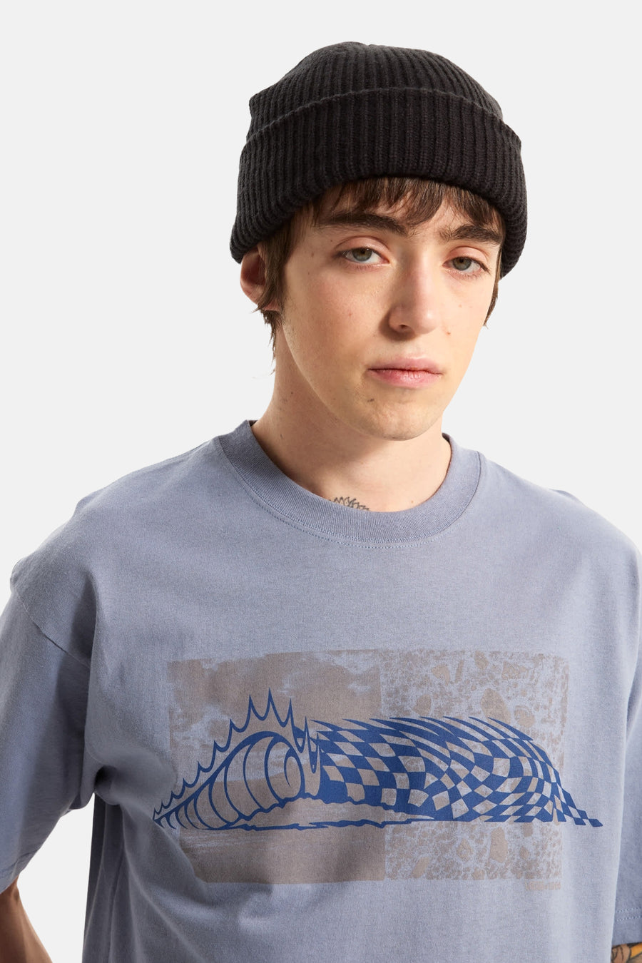 Blauw T-shirt van VANS “OFF THE WALL”, met een grafisch golfpatroon en een zwart gebreide muts.