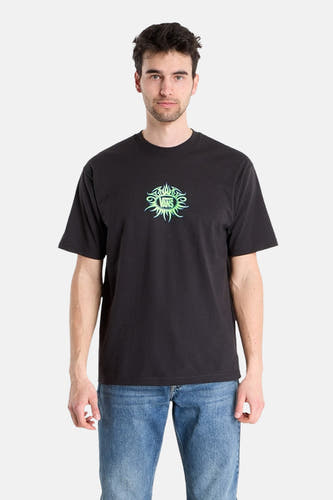 Zwart T-shirt van VANS “OFF THE WALL” met korte mouwen en groen logo op de borst, gedragen met een jeansbroek.
