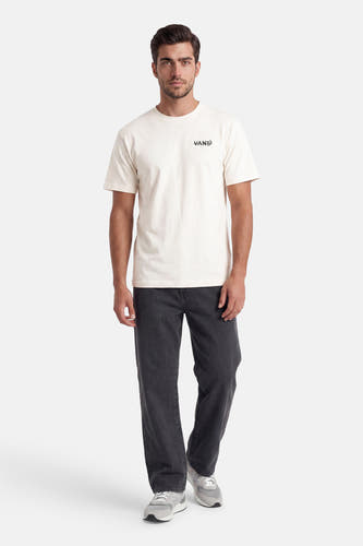 Ecru T-shirt met korte mouwen van VANS “OFF THE WALL” met zwart logo op de borst, gedragen bij een donkergrijze ribbroek en grijze sneakers.