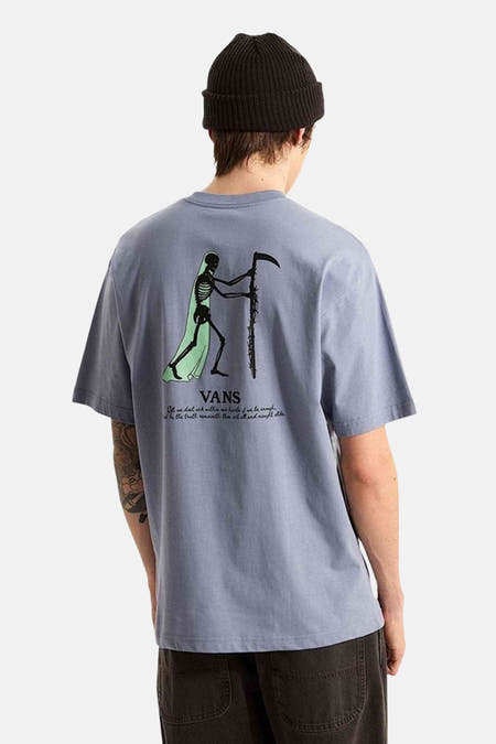 Blauwe korte mouwen t-shirt van VANS met skeletprint en tekst op de rug, gedragen door model in zwarte beanie, achterkant weergegeven