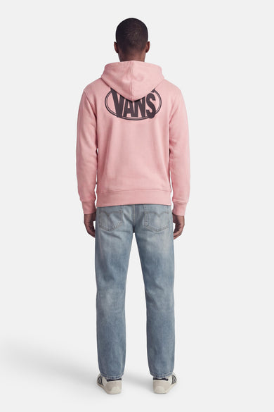 Pull à capuche rose VANS "OFF THE WALL", avec grand logo VANS dans le dos, combiné avec un jean bleu et des baskets blanches.
