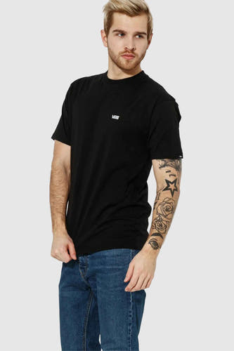 Zwart T-shirt van VANS “OFF THE WALL”, met korte mouwen en een logo op de borst; gedragen met een jeans.
