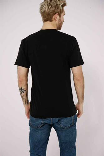 Zwart T-shirt van VANS “OFF THE WALL”, achterkant van een man in jeans.
