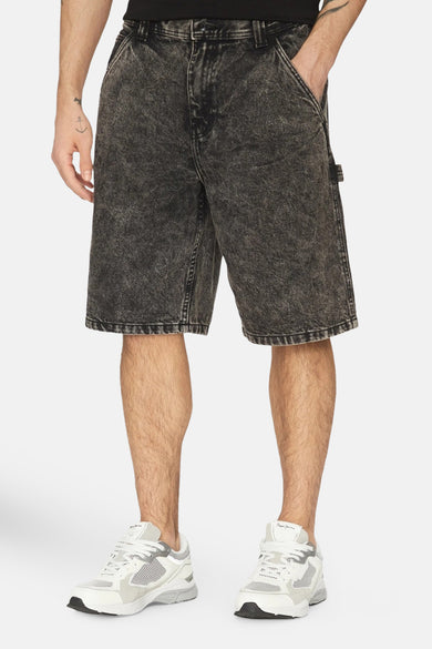 Een man in zwarte denim shorts en witte sneakers.