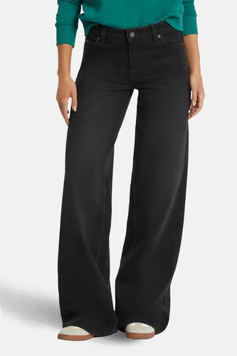 Zwarte wijde jeans van Guess® met denim textuur en wijd uitlopende pijpen.
