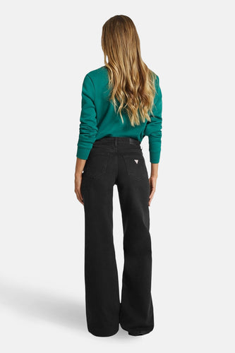 Zwarte wijde jeans van denim van Guess, achterkant zichtbaar, gecombineerd met een groene trui.