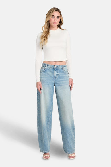 Lichtblauwe denim jeans special fit van Guess, met wijde pijpen en gedragen met een witte top.
