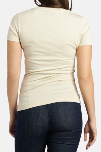 Ecru T-shirt met korte mouwen van Guess, met een strakke pasvorm, achterkant zichtbaar, gecombineerd met een donkere jeans.
