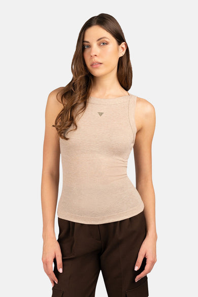 Beige top zonder mouwen van Guess, met een subtiel logo op de borst en gedragen met bruine broek.
