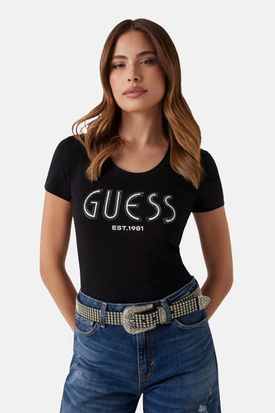 T-shirt noir à manches courtes de Guess, avec logo et détails strass, porté avec un jean et une ceinture.