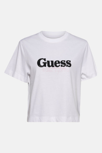 Wit T-shirt met korte mouwen van Guess met zwarte logo print en een roze opschrift eronder.
