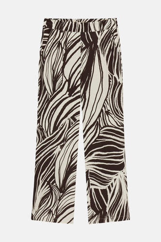 Crèmekleurige broek met abstract bladmotief van Guess®, met wijde pijpen, platliggend.