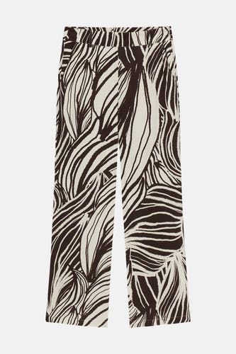 Crèmekleurige broek met donkerbruin abstract patroon van Guess, met wijde pijpen en riemlussen.