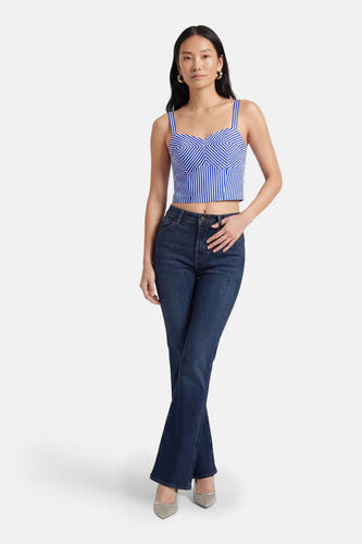 Blauwe blouse van Guess®, met gestreept patroon en korte snit, gecombineerd met donkere jeans en zilveren schoenen.