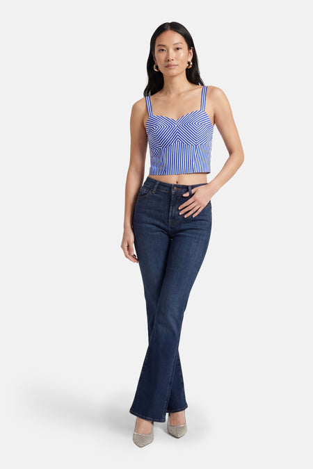 Blauwe blouse van Guess®, met gestreept patroon en korte snit, gecombineerd met donkere jeans en zilveren schoenen.