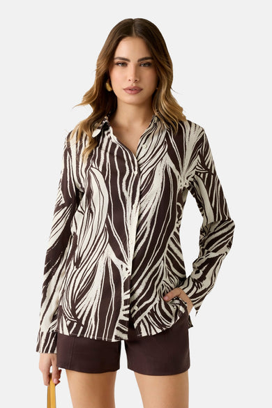 Multicolor overhemd met lange mouwen van Guess®, met een abstract zebrapatroon, gedragen met bruine shorts.
