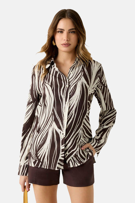 Chemise multicolore à manches longues Guess®, avec un motif zèbre abstrait, portée avec un short marron.