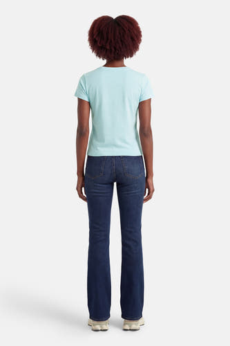 Blauw T-shirt met korte mouwen van Guess®, gezien van achteren, gecombineerd met donkerblauwe spijkerbroek en witte sneakers.