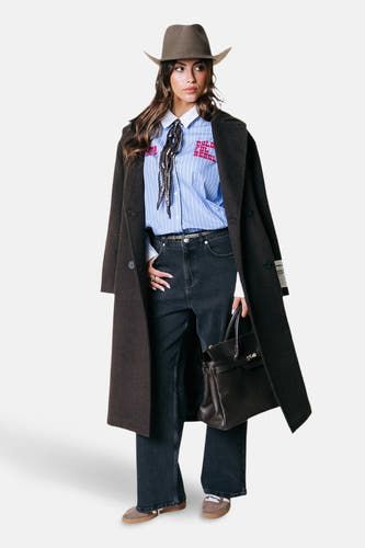 Chemise rayée bleue à longues manches de COLOURFUL REBEL, avec du texte rouge, associée à un manteau long et un chapeau de cowboy.