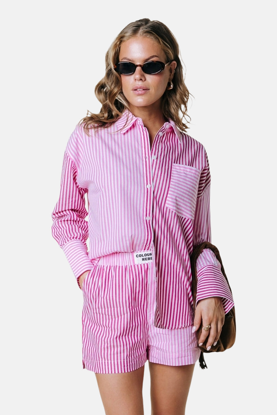 Roze gestreepte blouse met lange mouwen van COLOURFUL REBEL, verdeeld in twee tinten strepen, gedragen met bijpassende shorts.
