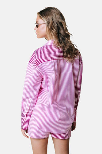 Roze blouse met lange mouwen van COLOURFUL REBEL, met roze verticale en horizontale strepen op het rugpand, gedragen van achteren door model met zonnebril.
