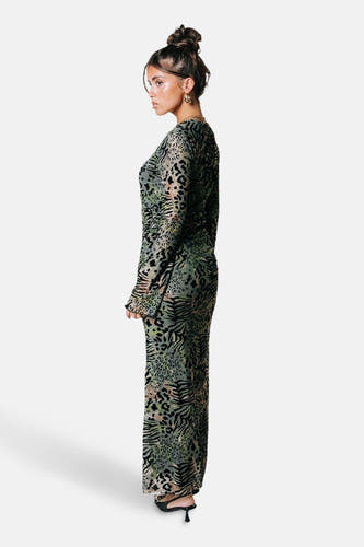 Groene jurk met lange mouwen van COLOURFUL REBEL, met luipaard- en zebramotief en gouden oorbellen.