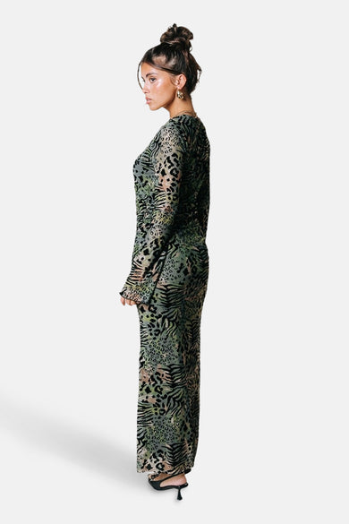 Robe verte avec des manches longues de COLOURFUL REBEL, avec des motifs de léopard et de zèbre et des boucles d'oreilles dorées.