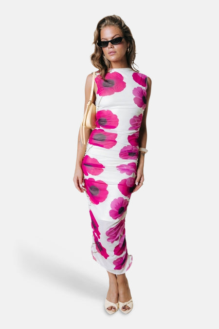 Mouwloze jurk in wit met roze bloemenprint van COLOURFUL REBEL, gerimpeld en gedragen door model met zonnebril en gele tas.