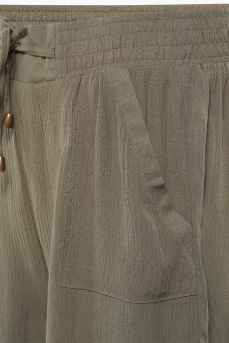 Groene korte broek van HAILYS met elastische taille en trekkoord, ribbeltextuur en voorzak, close-up zijaanzicht