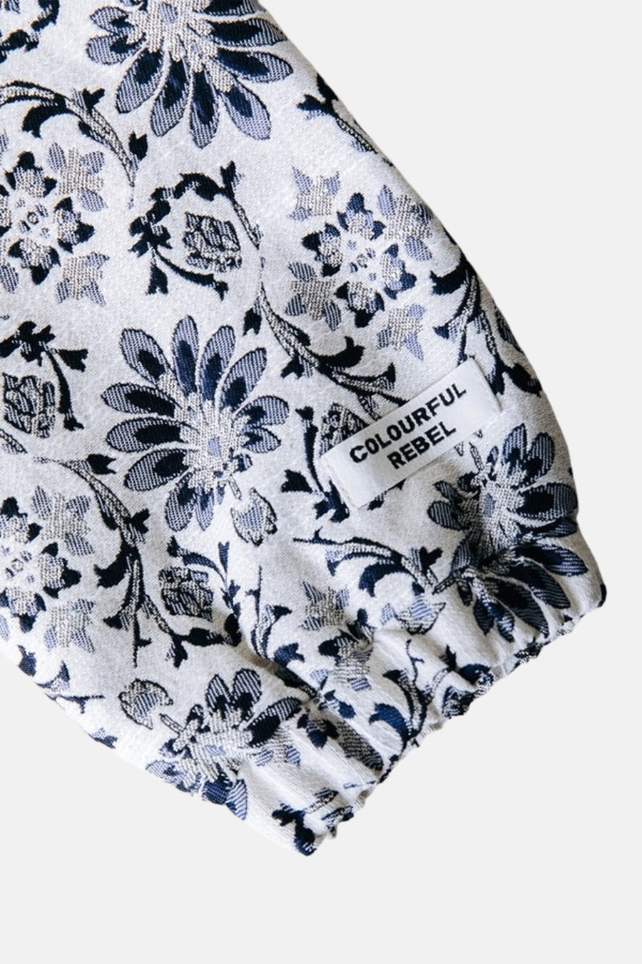 Multikleurige korte jas van COLOURFUL REBEL, met blauw en wit bloempatroon en zichtbaar merklabel.