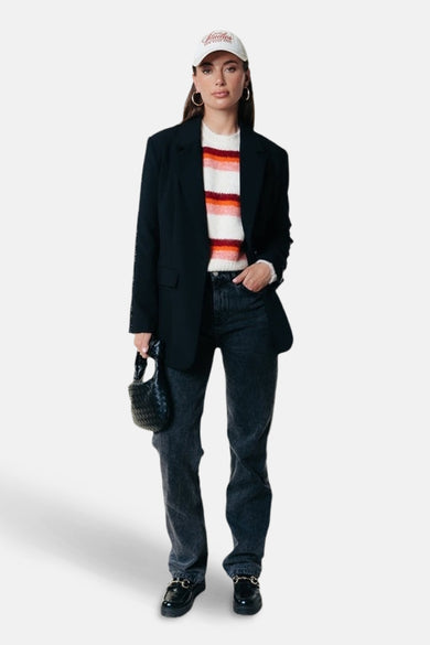 Multikleurige trui met ronde hals van Colourful Rebel, met horizontale strepen en gedragen met een zwarte blazer.

