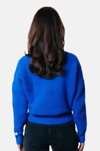 Blauwe trui met ronde hals van COLOURFUL REBEL, met lange mouwen, gedragen met een zwarte jeans, achteraanzicht.

