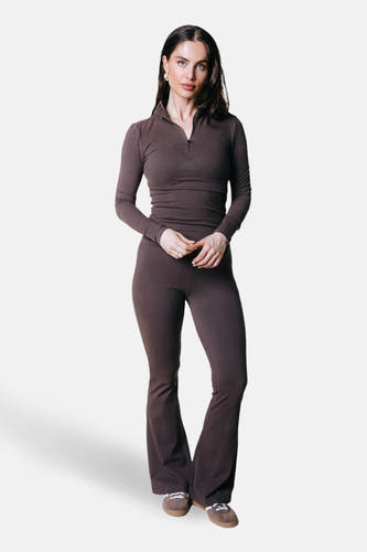 Bruine joggingbroek van COLOURFUL REBEL, gecombineerd met een bijpassende top met lange mouwen en ritssluiting en bruine sneakers.