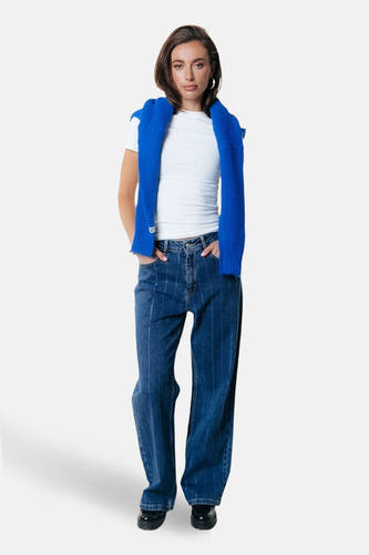 Donkerblauwe wijde jeans van COLOURFUL REBEL, met krijtstrepen en gedragen met een wit shirt en blauwe trui.