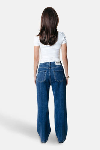 Donkerblauwe wijde jeans van COLOURFUL REBEL, met krijtstrepen en een wit label op de tailleband.