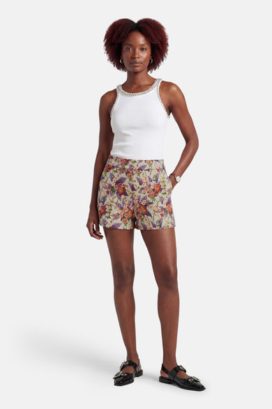 Short multicolore de COLOURFUL REBEL, à motif floral et porté avec un top blanc à strass et des sandales noires.